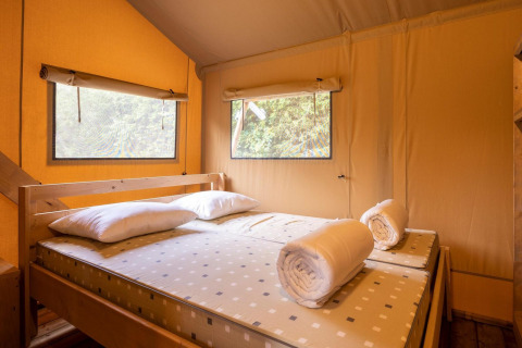 Interieur van een slaapkamer in safaritent Dreamer 49 bij Arden Parks - Signy l'Abbaye in Frankrijk.