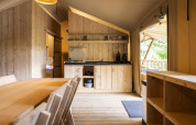 Vista interior de la tienda safari Dreamer 49 en Arden Parks - Signy l'Abbaye, Francia, con muebles de madera.