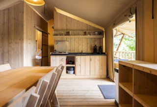 Vista interior de la tienda safari Dreamer 49 en Arden Parks - Signy l'Abbaye, Francia, con muebles de madera.