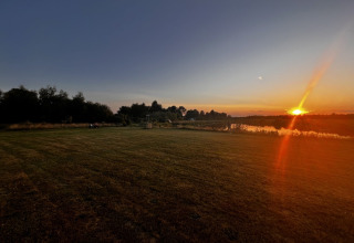 Coucher de soleil sur un champ paisible à Camping de Beerte, parc de vacances à Groningue, Pays-Bas.