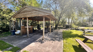 Pabellón de madera al aire libre en Camping de Beerte, Groningen, Países Bajos, rodeado de naturaleza.