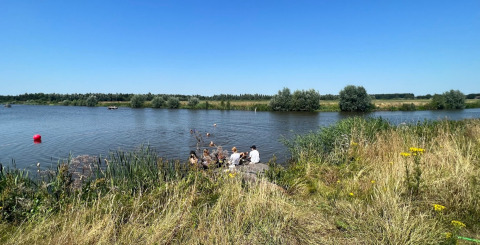 Villeggianti si rilassano sul lago presso Camping de Beerte, parco vacanze a Groningen, Paesi Bassi.