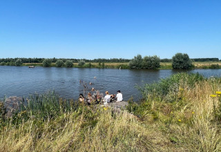Villeggianti si rilassano sul lago presso Camping de Beerte, parco vacanze a Groningen, Paesi Bassi.