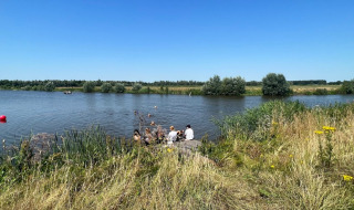 Turistas se relajan junto al lago en Camping de Beerte, un parque vacacional en Groningen, Países Bajos.