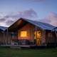 Safari-telt ved Holiday park De Boshoek i Holland ved solnedgang med oplyst indgang og veranda.