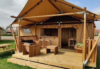 Tenda safari glamping con terrazza in legno e posti a sedere all'aperto all'Holiday park Eigen Wijze nei Paesi Bassi.