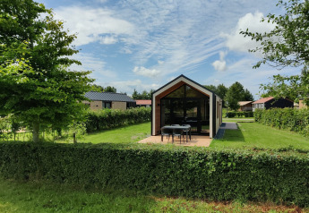 Tiny house moderna presso Holiday park Eigen Wijze nei Paesi Bassi, circondata da verde e alberi.