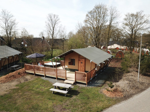 Tienda safari con zona wellness y terraza de madera en Holiday Park Sallandshoeve, Países Bajos, rodeada de naturaleza.