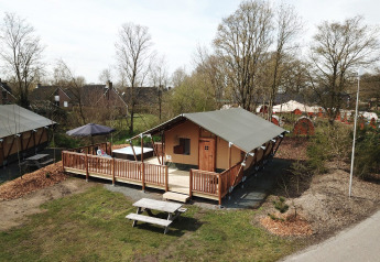 Safaritent met wellness en houten terras bij Vakantiepark Sallandshoeve, Nederland, omgeven door natuur.