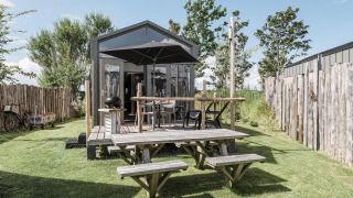 Cabaña Rescue en Duynpark Het Zwanenwater, Países Bajos, con terraza, mesas y cerca de madera.