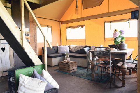 Hyggelig indretning af Beach Lodge Big med spisebord, sofa og træelementer i Duynpark Het Zwanenwater.