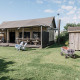 Billede af en hyggelig Wood Lodge Luxury ved Duynpark Het Zwanenwater i Holland, omgivet af grøn have.