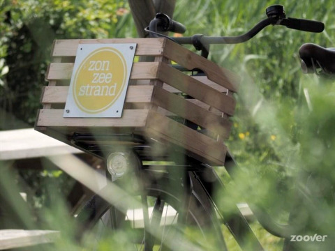 Fiets met houten krat 'zon zee strand' bij Tipitent de Jutter op Duynpark Het Zwanenwater, Nederland.