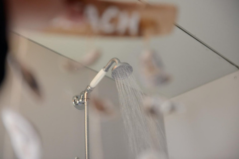 Shower head with running water inside Tipitent de Jutter at Duynpark Het Zwanenwater in the Netherlands.