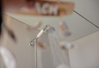 Shower head with running water inside Tipitent de Jutter at Duynpark Het Zwanenwater in the Netherlands.