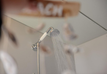 Shower head with running water inside Tipitent de Jutter at Duynpark Het Zwanenwater in the Netherlands.