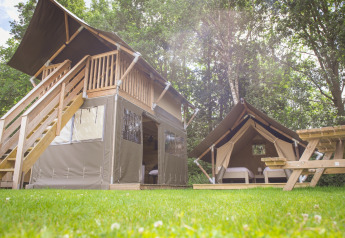 Safaritent met houten veranda en eigen sanitair op Holiday Park Sallandshoeve, Nederland, midden in de natuur.