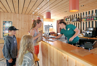 Famille commande au bar en bois au Camping d'Angers - Lac de Maine, village vacances en France.