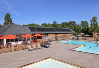 Swimmingpoolområde med liggestole og parasoller på Camping d'Angers - Lac de Maine i Centre-Val de Loire, Frankrig.