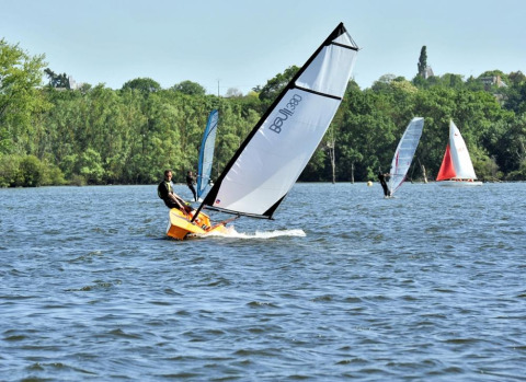 Aficionados disfrutan de la vela y el windsurf en el lago cerca de Camping d'Angers - Lac de Maine, Francia.