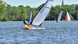 Aficionados disfrutan de la vela y el windsurf en el lago cerca de Camping d'Angers - Lac de Maine, Francia.