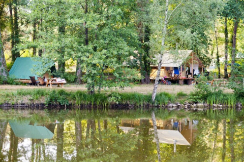 Campingplatz am See im Village Huttopia Lac de Rillé, Centre-Val de Loire, mit Zelten im Wald.