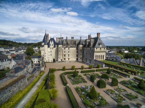 Vista aérea de un majestuoso castillo con jardines formales y edificios alrededor cerca de Rillé, Francia.