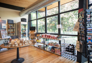 Boodschappenhoek en souvenirwinkel op Camping de Lyon met lokale producten, wijn en postkaarten.