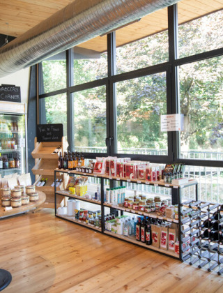 Rincón de comestibles y tienda de recuerdos en Camping de Lyon con productos regionales y postales.