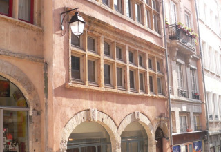 Historic building with arched entrances and multiple windows near Dardilly, Auvergne-Rhône-Alpes, France.