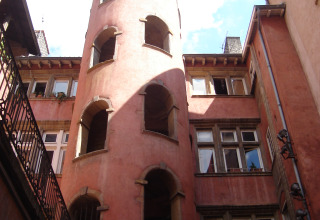 Ronde toren met open bogen aan een rood gebouw op Camping de Lyon, Auvergne-Rhône-Alpes, Frankrijk.