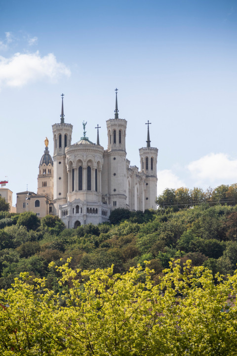La Basílica de Notre-Dame de Fourvière se alza imponente sobre las colinas verdes de Lyon, Francia.