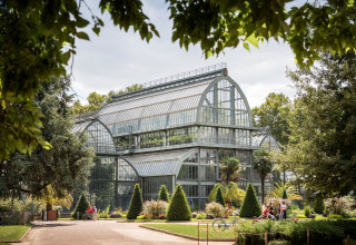 Großes Gewächshaus im botanischen Garten von Camping de Lyon, Auvergne-Rhône-Alpes, Frankreich, umgeben von Natur.