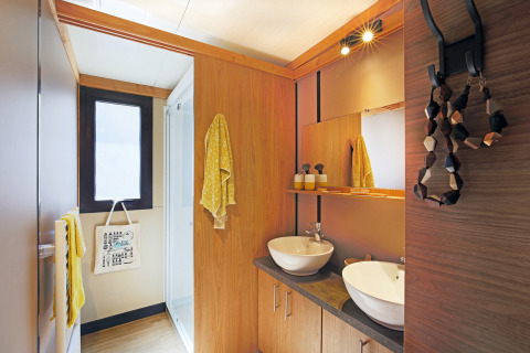 Baño moderno en el Chalet Ottawa de Camping d'Angers - Lac de Maine, Francia, con dos lavabos y detalles de madera.
