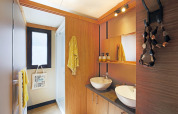 Baño moderno en el Chalet Ottawa de Camping d'Angers - Lac de Maine, Francia, con dos lavabos y detalles de madera.