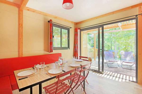 Vista interior del comedor y terraza del Chalet Ottawa en Camping d'Angers - Lac de Maine, Francia.