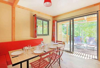Vista interior del comedor y terraza del Chalet Ottawa en Camping d'Angers - Lac de Maine, Francia.