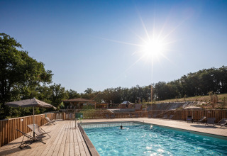 Solrig dag ved swimmingpoolen på Huttopia Pays de Cordes sur Ciel, feriepark i Occitanie, Frankrig.