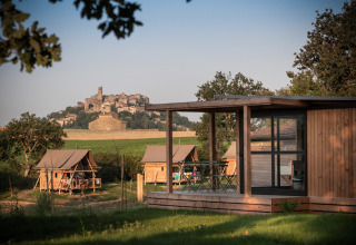 Cabanes en bois et tentes safari à Huttopia Pays de Cordes sur Ciel, avec vue sur Cordes sur Ciel.