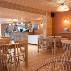 Interior de cafetería con paneles de madera en Huttopia Pays de Cordes sur Ciel en Occitania, Francia.