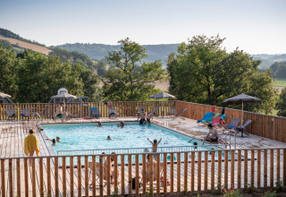 Gæster nyder poolen med udsigt over bakkerne på Huttopia Pays de Cordes sur Ciel, Occitanie, Frankrig.