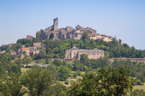 Vista de un pintoresco pueblo en lo alto de una colina cerca de Vindrac Alayrac, Occitania, Francia, rodeado de árboles.