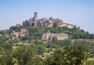 Blick auf ein malerisches Hügeldorf bei Vindrac Alayrac in Okzitanien, Frankreich, umgeben von viel Grün.