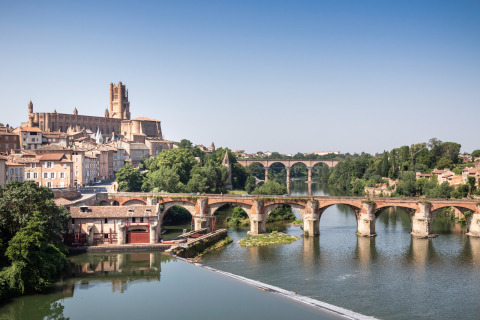 Vista de un puente de piedra histórico y la catedral de Albi junto al río cerca de Vindrac Alayrac, Occitania.