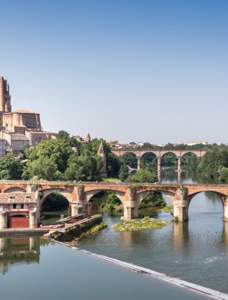 Vista de un puente de piedra histórico y la catedral de Albi junto al río cerca de Vindrac Alayrac, Occitania.