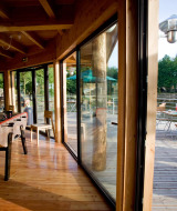 Mesa de futbolín interior y terraza exterior con huéspedes en Village Huttopia Senonches, Francia