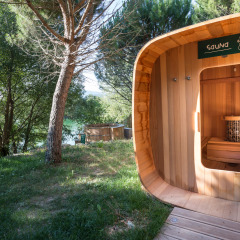 Sauna al aire libre de madera en Village Huttopia Dieulefit, rodeada de árboles en Auvergne-Rhône-Alpes, Francia.