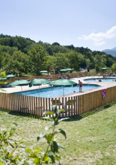 Piscina rodeada de naturaleza en el Village Huttopia Dieulefit, un parque vacacional en Auvergne-Rhône-Alpes, Francia.