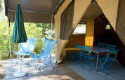 Tenda safari Tent Sweet al Camping d'Angers - Lac de Maine in Francia con sedie, tavolo e ombrellone.