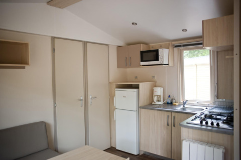 Keuken en zithoek in een Mobile home Cottage glamping accommodatie met moderne voorzieningen.